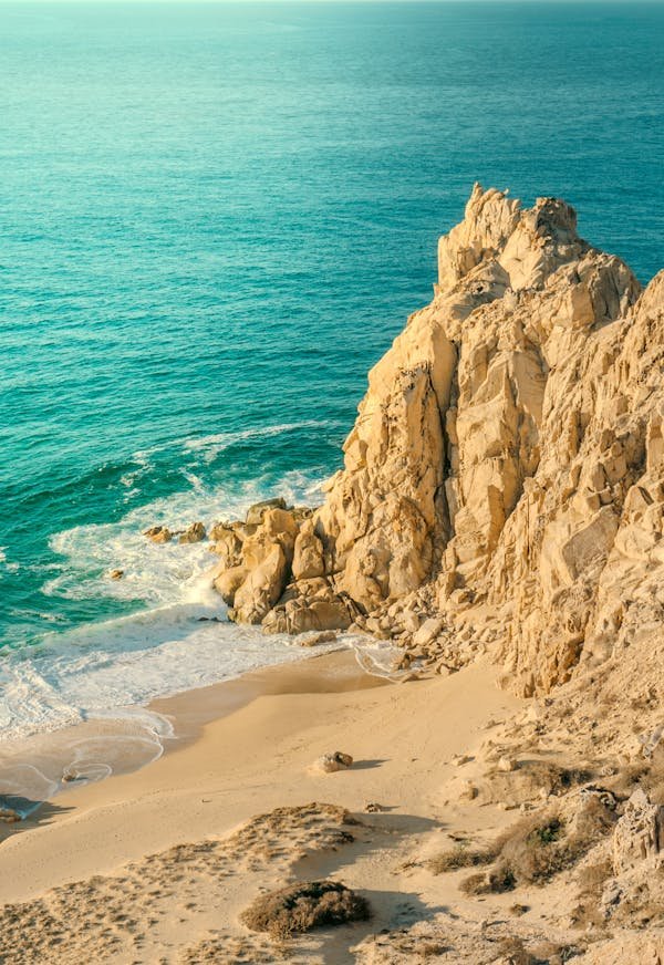 Una playa escondida y rocosa bañada por un hermoso mar turquesa brillante.