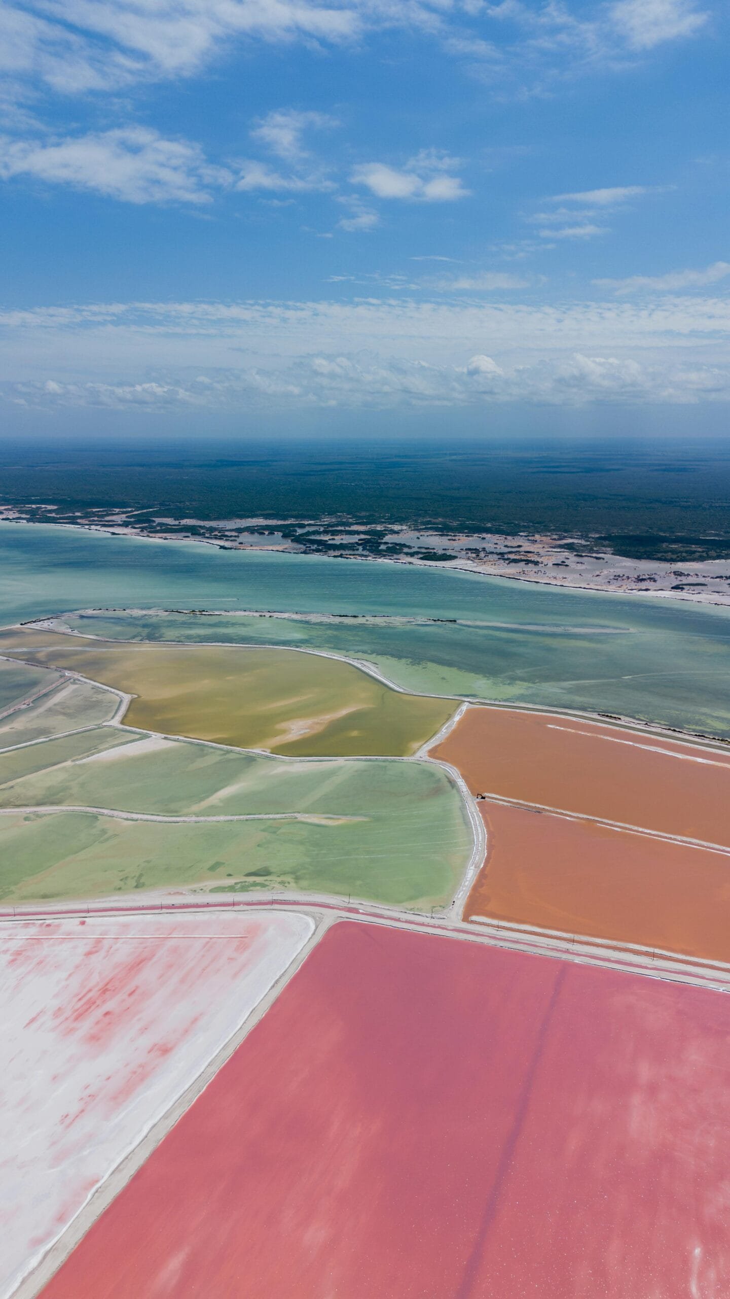 Vista aérea de hermosos terrenos de sal color rosa y verde, creando un paisaje hermoso de estas bonitas playas