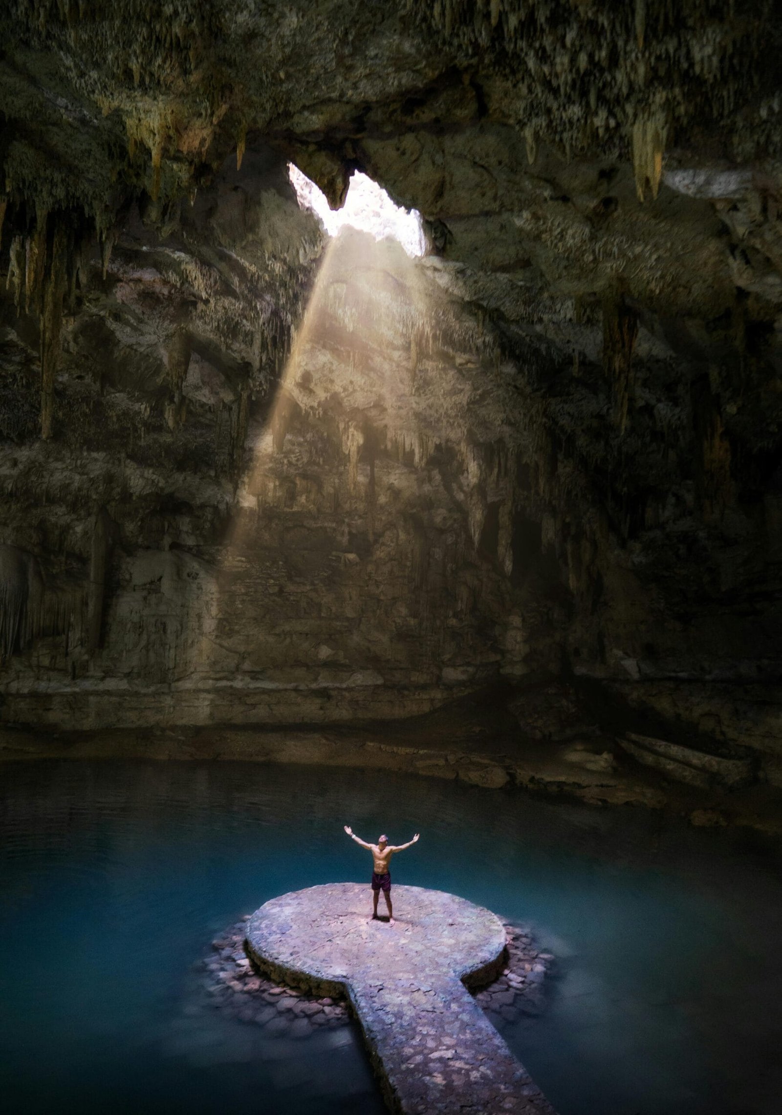 Imagen impresionante del cenote Suytun de agua dulce rodeado de naturaleza.
